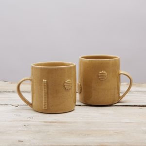 Pale Mustard Stoneware Mugs decorated with Cut out Shapes elizabeth-renton